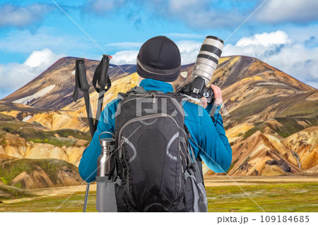 tourist photographer with a backpack looks at the beauty of nature in the mountains 109184685