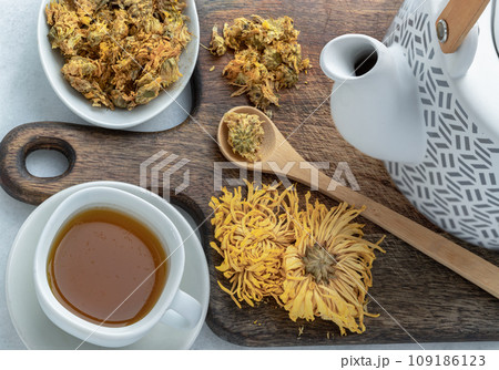 Chinese chrysanthemum flower tea and Dried chrysanthemum flower on wooden cutting board. Chinese chrysanthemum flower tea and Dried chrysanthemum flower on wooden cutting board. 109186123