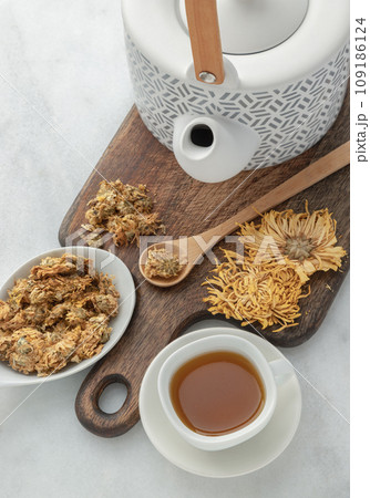 Chinese chrysanthemum flower tea and Dried chrysanthemum flower on wooden cutting board. Chinese chrysanthemum flower tea and Dried chrysanthemum flower on wooden cutting board. 109186124