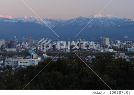 夕景立山あおぐ特等席冬の呉羽山からの雪化粧した薬師岳と富山市街地市役所付近展望 109187305