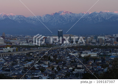 夕景立山あおぐ特等呉羽山からの富山市街地富山駅周辺と冠雪の剱岳立山連峰北アルプス呉羽山展望台から展望 109187307
