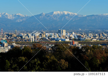 立山あおぐ特等席呉羽山から11月初冬の富山市街地と冠雪の北アルプス薬師岳 109187313
