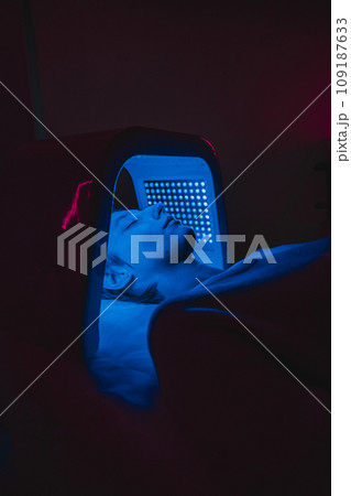 Facial skin care using an LED lamp in a beauty salon. Facial skin care using an LED lamp in a beauty salon. 109187633