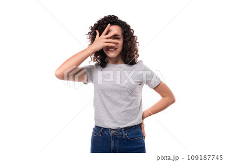 young european woman with black curly hair in a gray basic t-shirt looks happy on a white background young european woman with black curly hair in a gray basic t-shirt looks happy on a white background 109187745