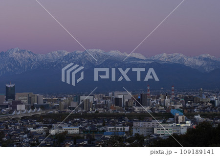 夕闇迫る富山市冬景色市街地と立山連峰北アルプス立山あおぐ特等席呉羽山展望台から 109189141