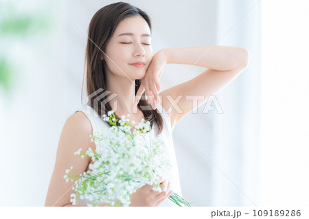 リビングでかすみ草の花束を持つ若い女性 109189286