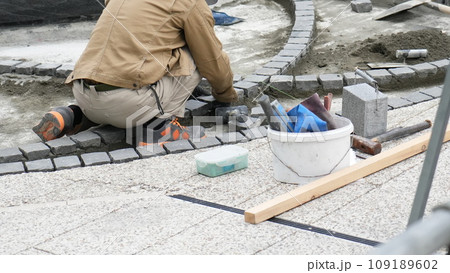 外構工事でレンガを敷く職人 109189602