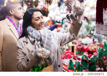 Portrait of woman customer near counter with Christmas gifts in evening time 109189871