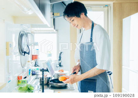 キッチンで料理をする男性 109190028