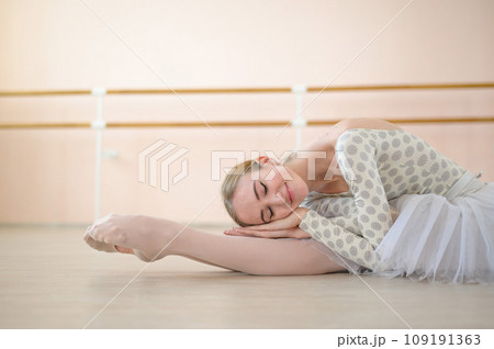 Beautiful ballerina is training in a dance class. Young flexible dancer posing in pointe shoes. A woman in a body and a white tutu dances a classical dance. Beautiful ballerina is training in a dance class. Young flexible dancer posing in pointe shoes. A woman in a body and a white tutu dances a classical dance. 109191363
