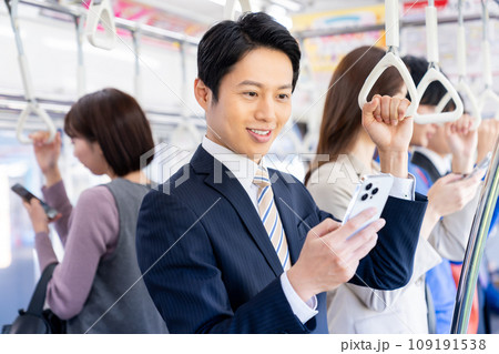 通勤でスマホを見るミドルのビジネスマン 撮影協力「京王電鉄株式会社」 通勤でスマホを見るミドルのビジネスマン 撮影協力「京王電鉄株式会社」 109191538