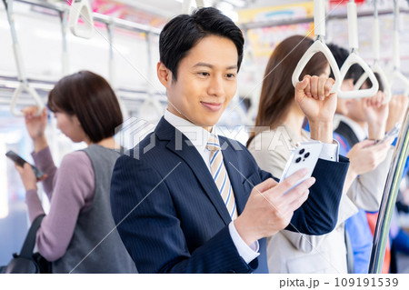 通勤でスマホを見るミドルのビジネスマン 撮影協力「京王電鉄株式会社」 通勤でスマホを見るミドルのビジネスマン 撮影協力「京王電鉄株式会社」 109191539