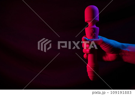 Woman holding a vibrator in neon pink and blue light. Woman holding a vibrator in neon pink and blue light. 109191883