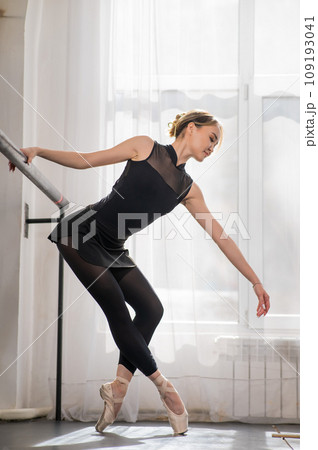 A beautiful Asian ballerina is training in a dance class. Vertical photo. A beautiful Asian ballerina is training in a dance class. Vertical photo. 109193041