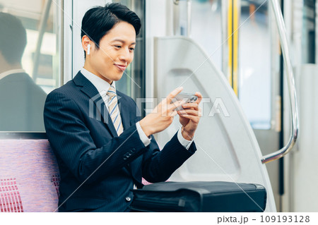 通勤でスマホを見るミドルのビジネスマン　撮影協力「京王電鉄株式会社」 109193128