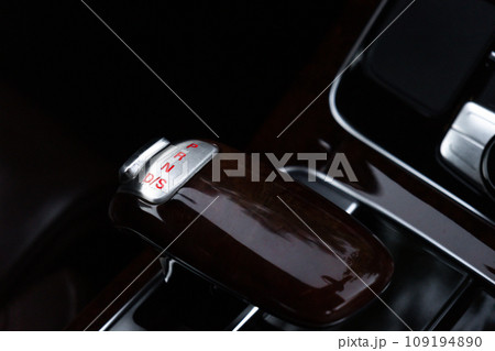 Interior of modern luxury car. Details of automatic transmission gear shift, multimedia control system, car control panel, Air Vent Red emergency button and dashboard inside. Prestige sport automobile 109194890