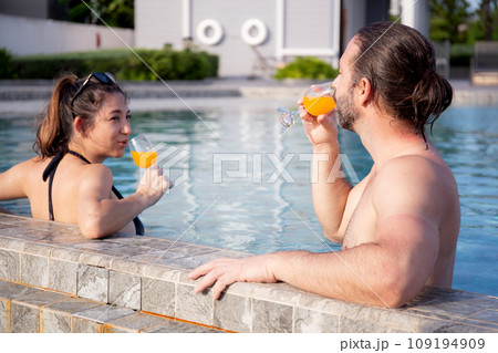 Happiness couple relax in swimming pool together at hotel resort, summer and honeymoon. 109194909