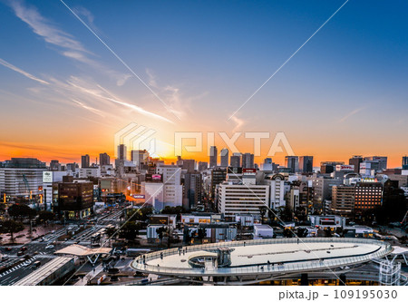 水の宇宙船越しに夕焼けの名駅地区高層ビル群を望む 109195030