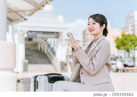 駅・空港から配車アプリでタクシー・レンタカーを呼ぶ女性（出張・レンタカー・旅行） 109195082