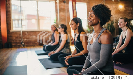 Tranquil woman meditates with group during yoga session recreation with mindfulness Tranquil woman meditates with group during yoga session recreation with mindfulness 109195179