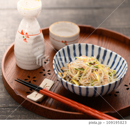 お盆にのせた春雨サラダと日本酒 109195823