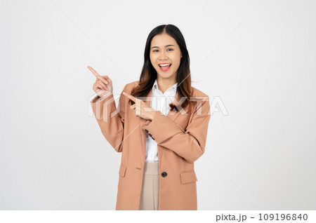 Young businesswoman, smiling while pointing finger left and showing thumbs up, recommending product Young businesswoman, smiling while pointing finger left and showing thumbs up, recommending product 109196840