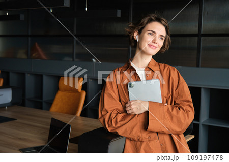 Portrait of young woman, company employee, office worker in casual clothes working with tablet in conference room, planning team meeting 109197478