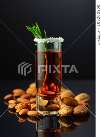 Italian liqueur Amaretto with almonds nuts on a black background. Italian liqueur Amaretto with almonds nuts on a black background. 109200800