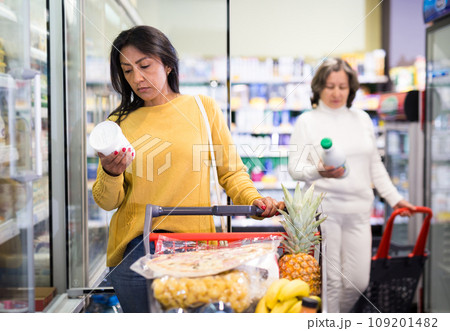 Latin american woman choosing dairy products in grocery shop Latin american woman choosing dairy products in grocery shop 109201482