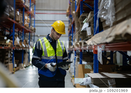 Employees check products using a tablet in the warehouse. 109201969
