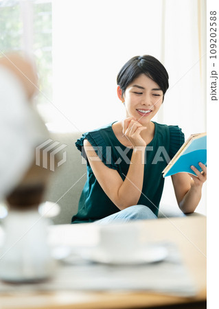 リビングでガイドブックを見る女性 109202588
