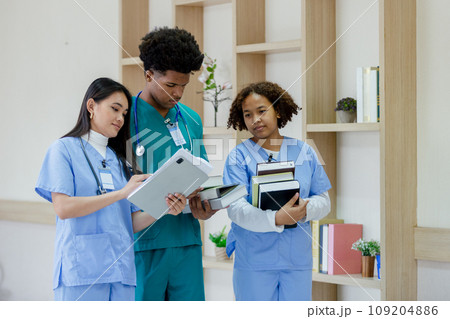 Group of medical student holding book walking front classroom in hospital university. 109204886