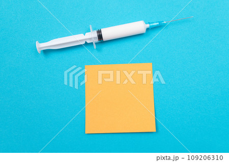 Vaccination or Revaccination Concept - A Medical Syringe on Blue Table 109206310