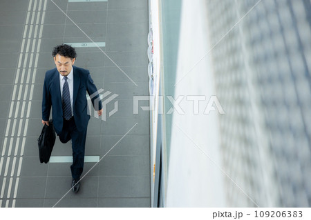 スマホで通話する髭の男性 109206383