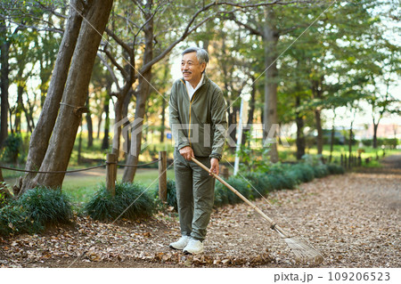 熊手で落ち葉をかき集める男性 熊手で落ち葉をかき集める男性 109206523