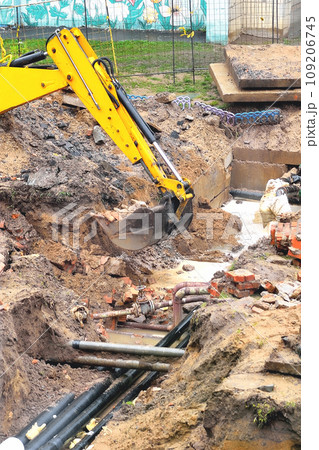 the excavator is working on emergency work to repair the pipeline, a breakthrough in the water supply and heating pipeline.  selective focus, copy space 109206745