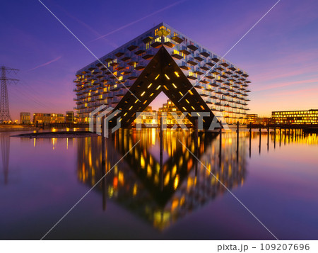 Amsterdam, Netherlands. A cityscape during sunset. A apartment building near the water in the bay. Amsterdam, Netherlands. A cityscape during sunset. A apartment building near the water in the bay. 109207696
