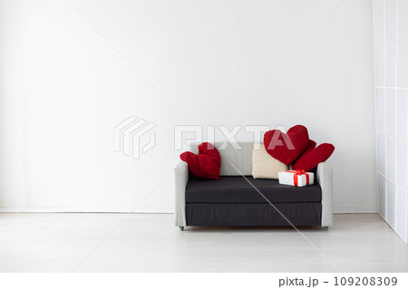 A sofa with a heart-shaped pillow and gifts in a bright room A sofa with a heart-shaped pillow and gifts in a bright room 109208309