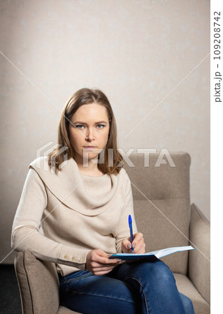 Discreet psychologist sitting with notebook for notes 109208742