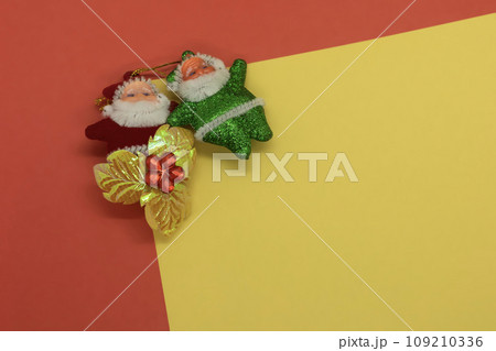 Santa Claus and Christmas decoration on a red and yellow background. Top view with copy space Santa Claus and Christmas decoration on a red and yellow background. Top view with copy space 109210336
