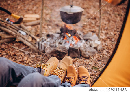 Dad and son sitting in a tent by the fire 109211488