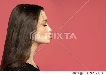 A kiss of a pretty brunette on a red background A kiss of a pretty brunette on a red background 109212151