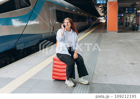 Upset woman talking over phone disappointed hear bad news, sad pensive girl speaking having unpleasant phone conversation and standing at railroad station platform. Full body, Negative emotion 109212195