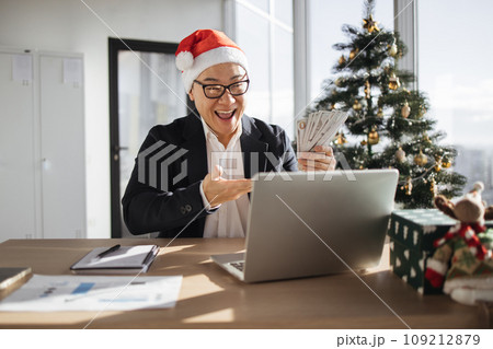Asian attractive man in Santa hat lifting hands with cash papers 109212879