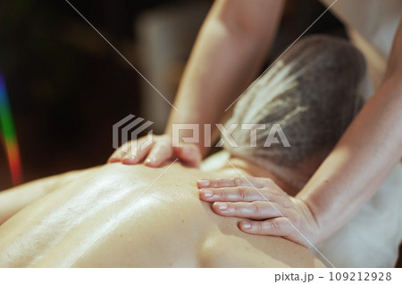 Medical massage therapist in massage cabinet massaging client Medical massage therapist in massage cabinet massaging client 109212928