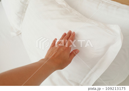 A soft, white pillow on the bed 109213175