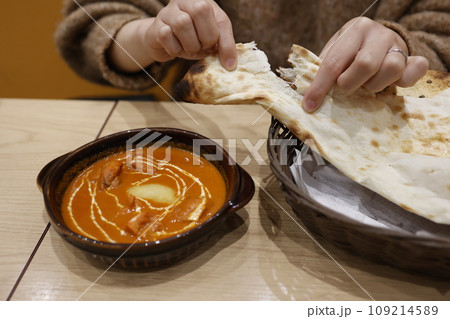 日本のインド料理店で提供されるバターチキンカレーとナンのセット 109214589