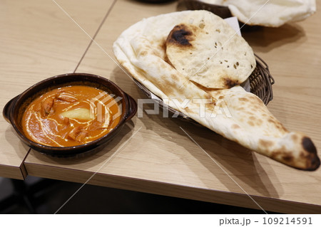 日本のインド料理店で提供されるバターチキンカレーとナンのセット 日本のインド料理店で提供されるバターチキンカレーとナンのセット 109214591