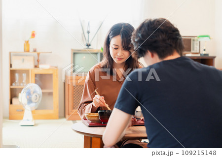 ドラマのようなレトロな雰囲気の食卓でごはんを食べる若い夫婦 ドラマのようなレトロな雰囲気の食卓でごはんを食べる若い夫婦 109215148