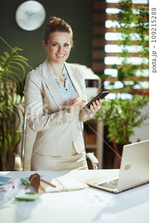 smiling woman employee in green office using smartphone smiling woman employee in green office using smartphone 109215289